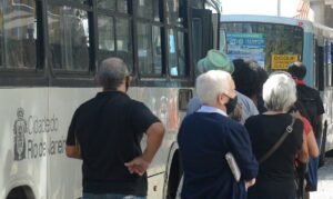 Pessoas esperam em ponto de ônibus no centro do Rio de Janeiro