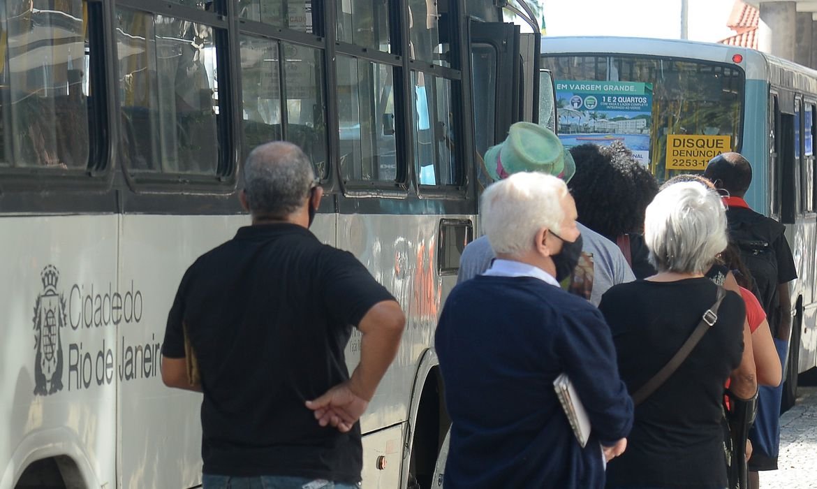 Pessoas esperam em ponto de ônibus no centro do Rio de Janeiro